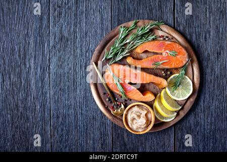 Smoked salmon on a wooden cutting board, garnished with herbs and ...