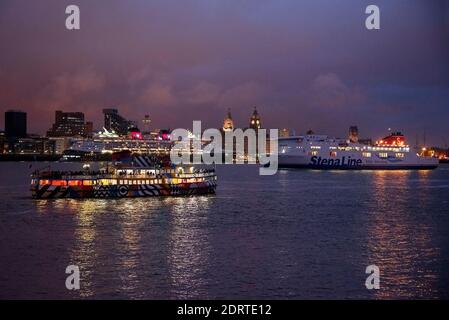 The Disney Magic cruise liner ship at night leaving Liverpool  with Mersey Ferries Dazzle ferry Snowdrop and Ro Ro ferry Stena Lagan. Stock Photo