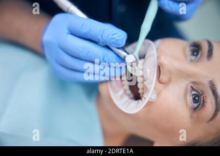 Dentist treating young beautiful female in office Stock Photo