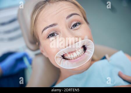 Happy pretty woman after dental procedure in clinic Stock Photo