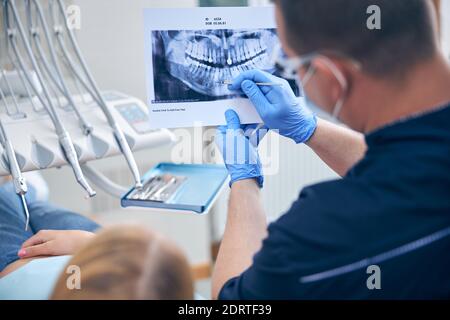 Surgeon with female discussing her jaw x-ray Stock Photo
