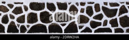 Very roughly worked house wall made of lava stones and white plaster Stock Photo