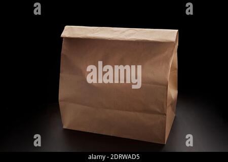 Disposable paper bag for food delivery, on black background with place for text Stock Photo