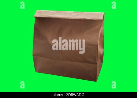 Brown disposable paper food delivery bag on green background with place for text Stock Photo