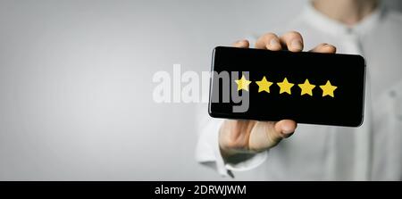 excellent service and customer feedback. woman holding phone with 5 star rating on screen. copy space Stock Photo