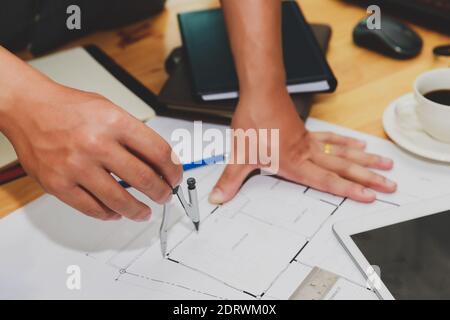 Engineer or architect using divider compass tools on blueprint in office on site. Stock Photo
