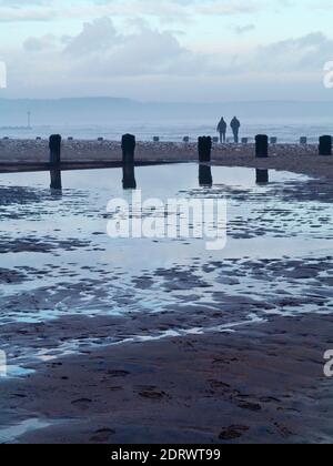 Winter view of the beach at Bridlington a popular seaside resort in the East Riding of Yorkshire England UK with couple walking in distance. Stock Photo