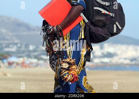 Sperlonga, Italy - June 30, 2018: A street vendor of African origins on the beach Stock Photo