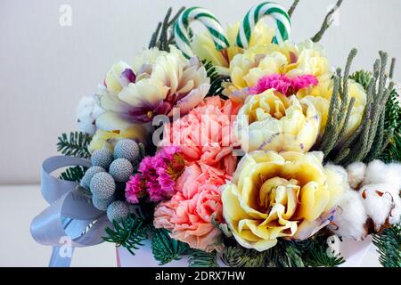 Beautiful winter floral composition with tulips, carnations, cotton flower, spruce branches Stock Photo