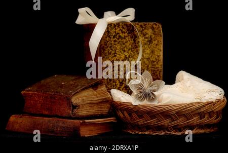 Very old and worn out books and old rattan basket with black background Stock Photo