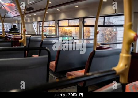 As the government announces the move from Tier 2 to Tier 3 before Christmas, a lone bus pasenger travels on the top deck through Piccadilly during the second wave of the Coronavirus pandemic, on 14th December 2020, in London, England. Stock Photo