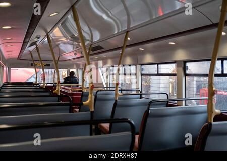 As the government announces the move from Tier 2 to Tier 3 before Christmas, a lone bus pasenger travels on the top deck through Piccadilly during the second wave of the Coronavirus pandemic, on 14th December 2020, in London, England. Stock Photo