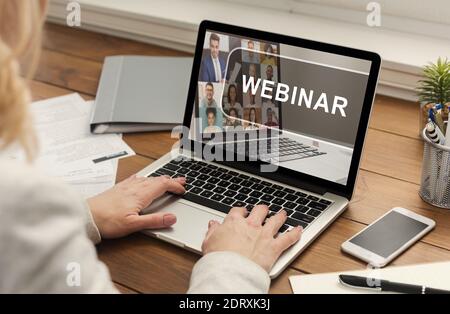 Unrecognizable woman typing on laptop with webinar inscription Stock Photo