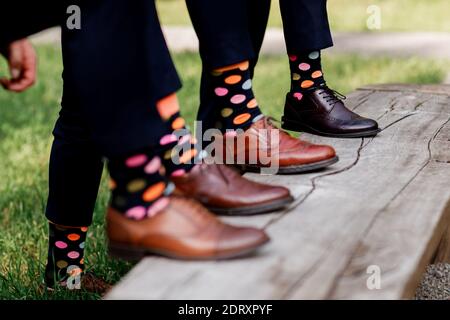 stylish men's socks. Stylish suitcase, men's legs, multicolored socks and new shoes. Concept of style, fashion, beauty and vacation. Stock Photo