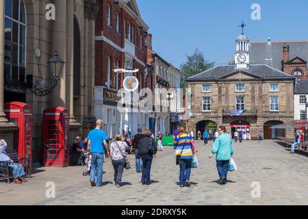Shoppers walking along Pontefract Market Place on a sunny Summer day Stock Photo