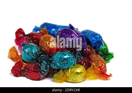 Candies wrapped in colorful foil against a white background Stock Photo
