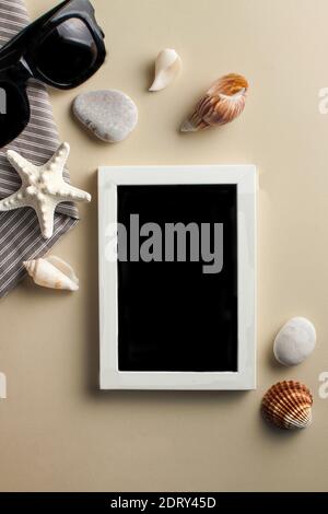 Flatlay white photo frame with starfish, sunglasses and shells on colored background. The concept of travel Copy space Stock Photo