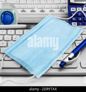 Face mask and office background with PC keyboard Stock Photo