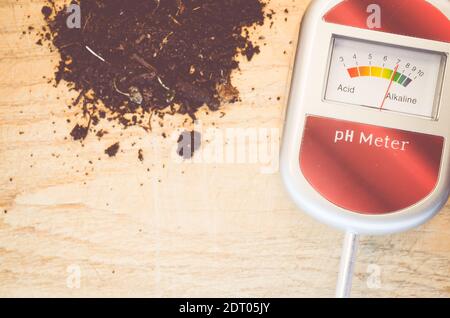 A top view of an analog tool to measure soil on a wooden table Stock Photo