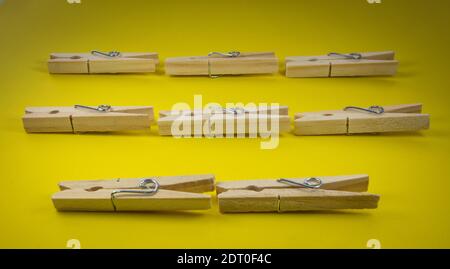 Closeup shot of wooden clothespins on a yellow background Stock Photo