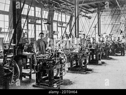 Early 20th century black and white archival photo showing workers and machines for casting types for typesetters at foundry floor of type foundry Stock Photo