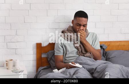 Sick Black Man Coughing Suffering Pneumonia Sitting In Bed Indoors Stock Photo