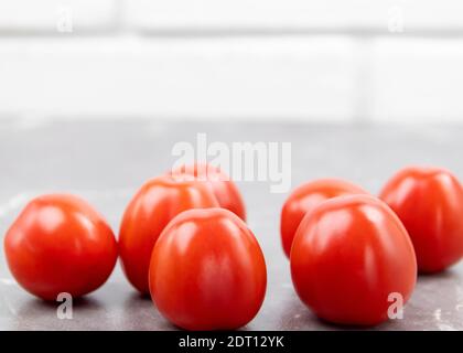 Cherry tomatoes on a marble table. Freshly picked small tomatoes. Fresh and healthy vegetables as background with place for text Stock Photo