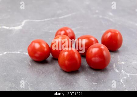 Cherry tomatoes on a marble table. Freshly picked small tomatoes. Fresh and healthy vegetables as background with place for text Stock Photo
