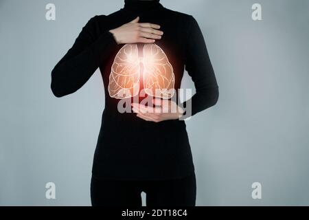 Illustration of lungs detox with highlighted organ and contrast hands on dark background. Low key photo with copy space toned in dark green colors. Stock Photo