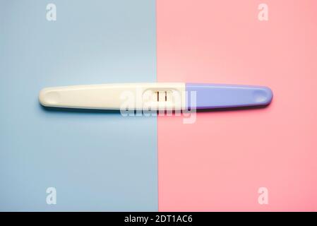 positive pregnancy test with two stripes on a pink and blue background Stock Photo