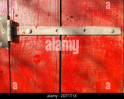 Photo of an old rustic and worn wood door painted red Stock Photo