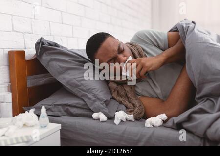 Sick African Man Coughing Suffering From Coronavirus Lying In Bed Stock Photo