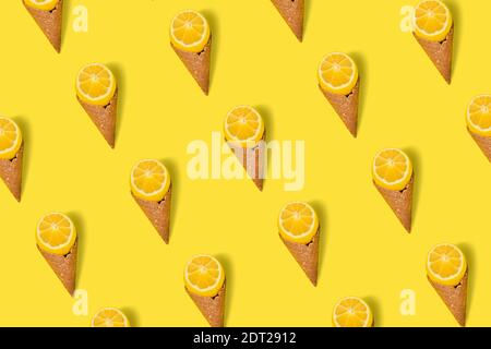 Pattern Cut Lemon with ice cream cone on bright illuminating yellow background. Flat lay. Fruit ice cream concept Stock Photo