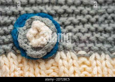 Knitted pattern of threads in two colors and styles. Small flower on a scarf Stock Photo