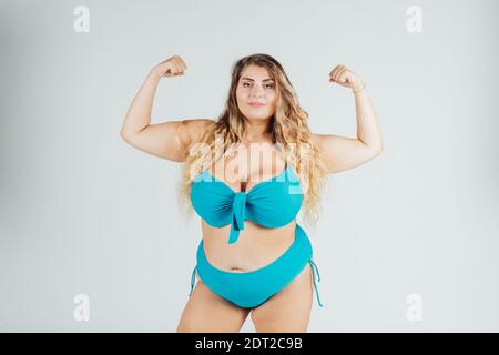 Young woman wearing bikini, flexing muscles Stock Photo