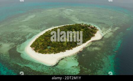 Small tropical island on an atoll with beautiful sandy beach surrounded by coral reef from above. Tropical island and coral reef. Summer and travel vacation concept, Camiguin, Philippines, Mindanao Stock Photo