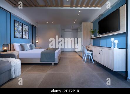 Modern blue interior small studio apartment with bedroom, kitchen, living room in single space. Contemporary Scandinavian loft style hotel flat with w Stock Photo