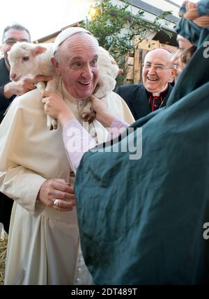 A woman participating in a live nativity scene places a lamb on Pope Francis's shoulders at the Church of St Alfonso Maria dei Liguori in the outskirts of Rome, Italy on January 6, 2014. The event was part of the feast of the Epiphany, which commemorates three kings' visit to the baby Jesus after his birth in Bethlehem. Photo by ABACAPRESS.COM Stock Photo