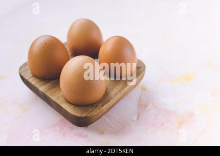 Four brown eggs in a wooden storage organizer box Stock Photo