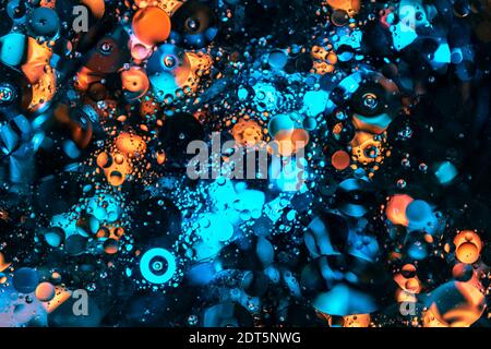 blurred abstract fluid background with flowing big bubbles and bokeh lights of blue, cyan and orange color. mysterious backdrop with round transparent Stock Photo