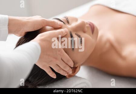Spa therapist making relaxing head massage for beautiful asian woman in salon Stock Photo