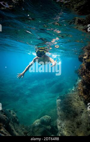 Boy wearing scuba mask swimming underwater Stock Photo