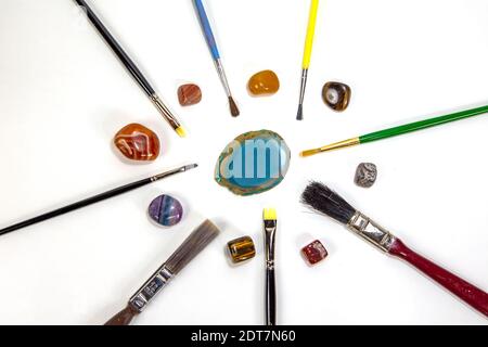Different Brushes and colored, semi-precious, semi-precious stones, photo on a white background Stock Photo