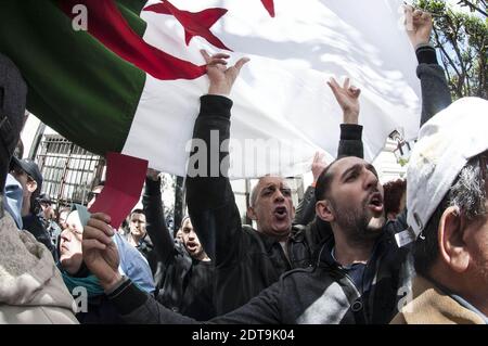 Algerian supporters of a movement called Barakat (meaning in Arabic ‘That's enough’), campaigning for new leadership in Algeria, demonstrate holding banners and shouting slogans against Algeria's current President Bouteflika Abdelaziz running for a fourth term in the April 17 elections, outside the central school in downtown Algiers on March 27, 2014. The 77-year-old leader's decision to seek re-election despite serious health problems, which confined him to hospital in Paris for three months last year, has drawn heavy criticism not only in opposition ranks but also from some within the regime Stock Photo