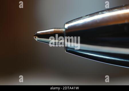 Extreme close up of a ballpoint pen tip with soft focus background Stock Photo
