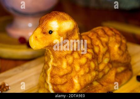 preparation of treats for traditional Orthodox Christmas - handmade baked cookies in the form of lambkin on a wooden table Stock Photo