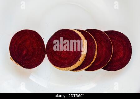On white background are slices of beetroots laid out in a line with thier cross section upward. Stock Photo