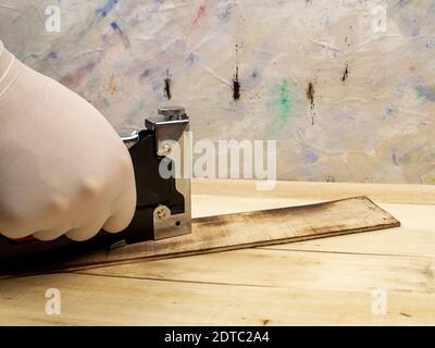 Man fastens boards with a stapler Stock Photo