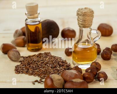 Oil in a bottle and nuts on a wooden background Stock Photo