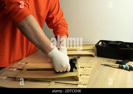 A man in a medical protective mask works with a stapler with a tree Stock Photo